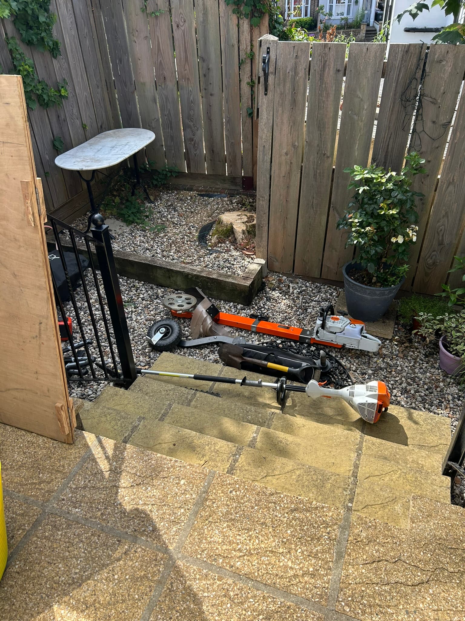 Tight gravelled garden corner with the old tree stump still in place before grinding