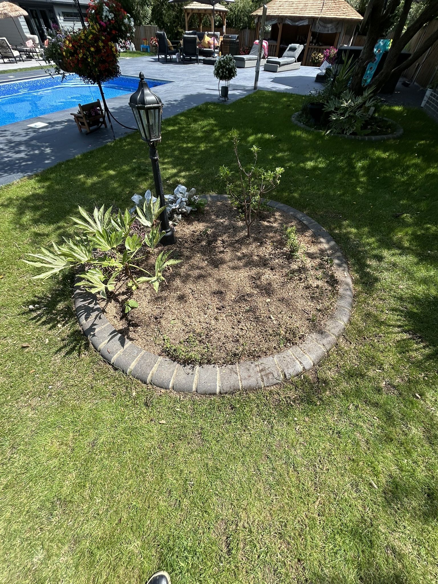 The finished flower bed with the stump removed, soil raked level and replanted