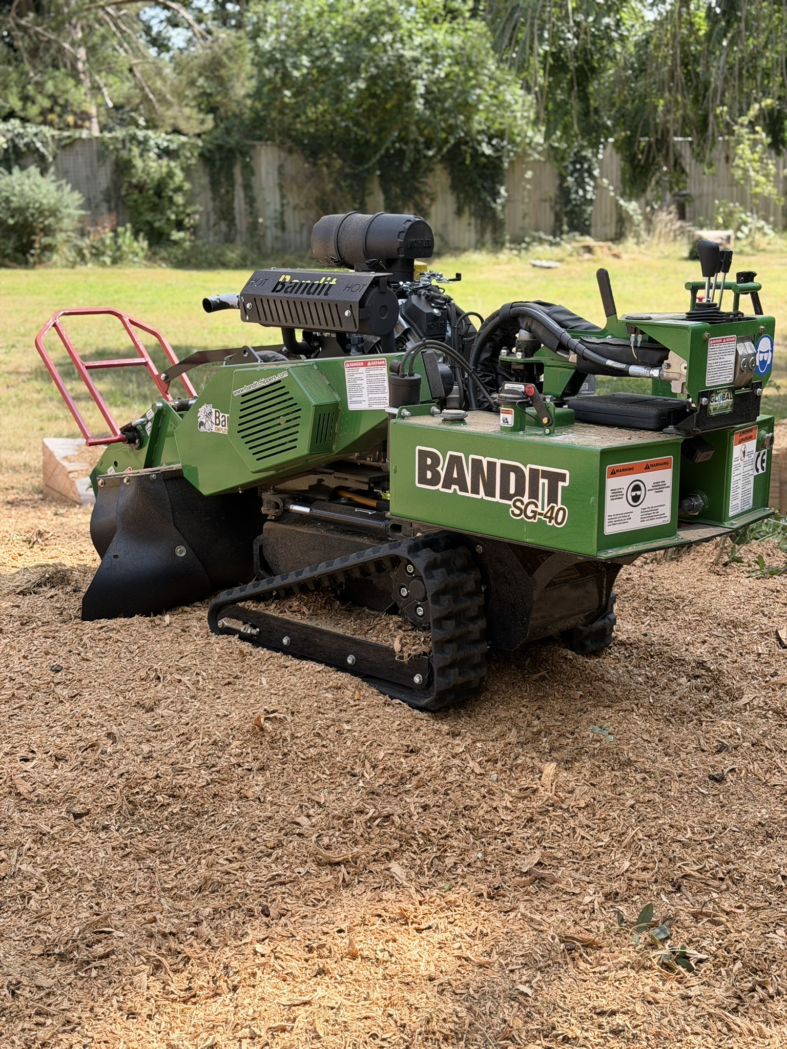 Tracked stump grinder parked on fresh wood chippings on site, ready to start work