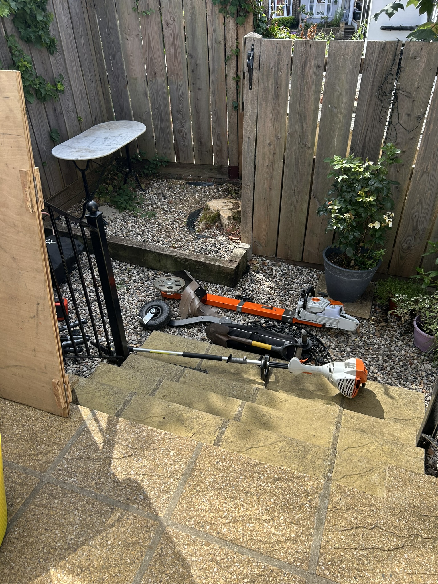 Tight gravelled garden corner with the old tree stump still in place before grinding